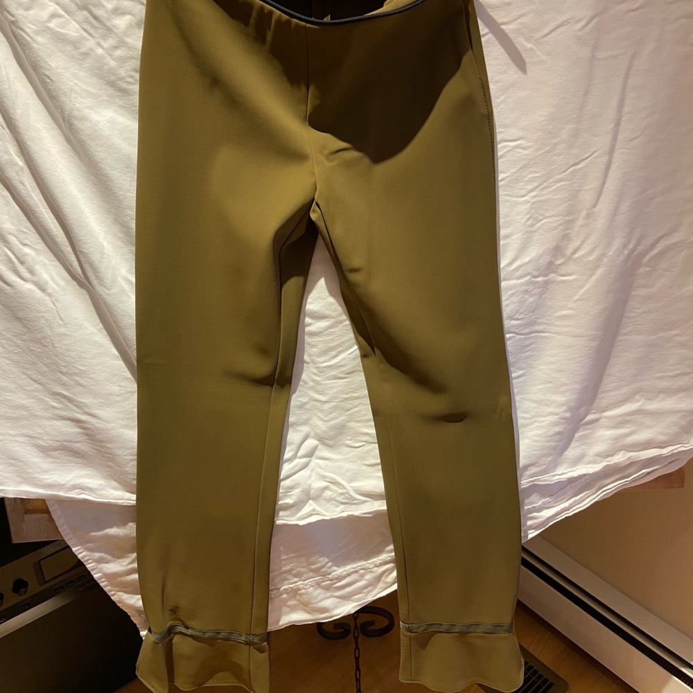 Prada pants with slightly flared bottom-side zipper piping detail around waist